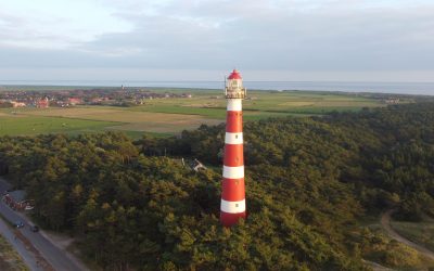 A beautiful aerial view of the Bornrif Lighthouse surrounded by lush trees in Ameland, the Netherlands